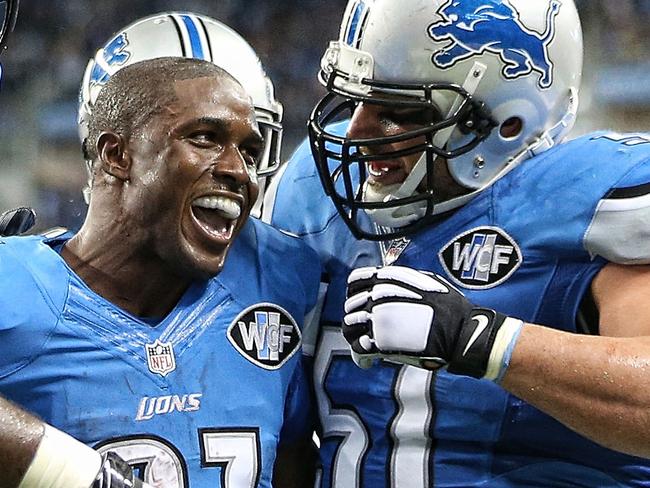 DETROIT, MI - SEPTEMBER 21: Reggie Bush #21 of the Detroit Lions celebrates with teammates Cornelius Lucas #77 and Dominic Raiola #51 after scoring on a 21 yard touchdown during the fourth quarter of the game against the Bay Packers at Ford Field on September 21, 2014 in Detroit, Michigan. (Photo by Leon Halip/Getty Images)