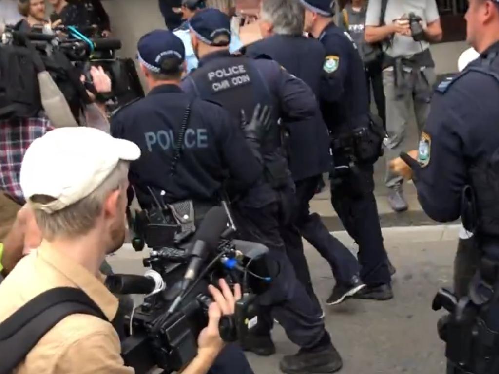 Men in suits have been led away. Picture: Phoebe Loomes