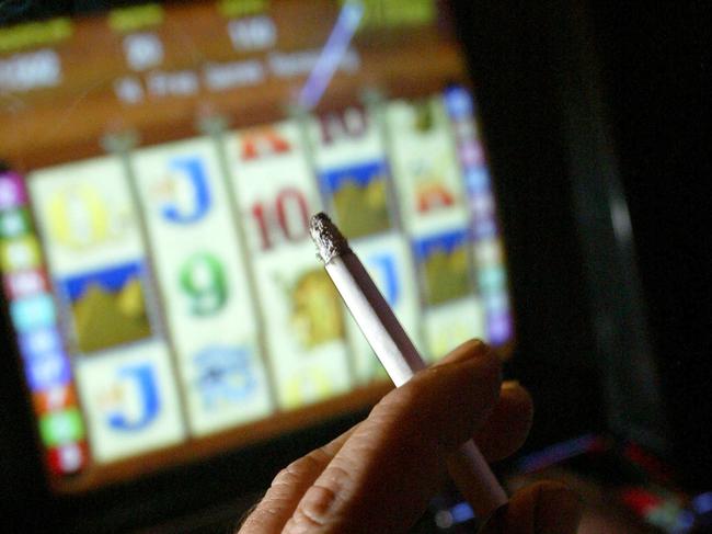 A smoker and gambler playing the pokies in a Sydney pub today. pic Toby Zerna 7/7/05