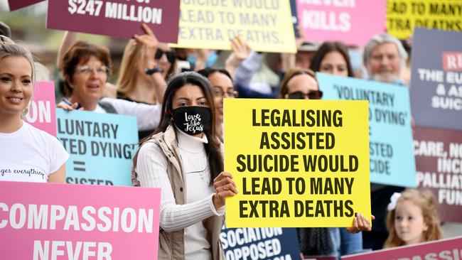 Anti-euthanasia protesters hold signs outside Parliament House in Brisbane. Picture: NCA NewsWire / Dan Peled