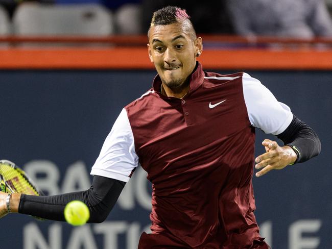 Nick Kyrgios hits a return in his match against Stan Wawrinka.