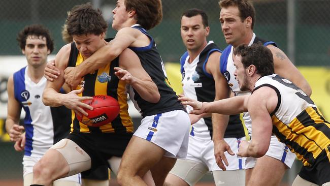 Upwey Tecoma’s Ryan Van Hoorn looks to break a Warburton Millgrove tackle.