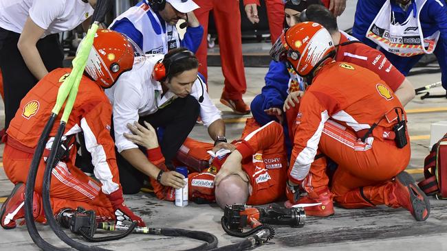 Ferrari mechanic, Francesco, lies on the ground after his leg was run over by Kimi Raikkonen during a pit stop.