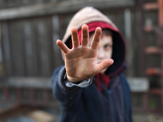 dramatic portrait of a little homeless boy, dirty hand, poverty, city, street. iStock Image