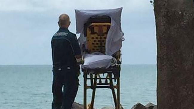 Paramedic Graeme Cooper stood with the patient by the seaside, filling a bag with saltwater for her.