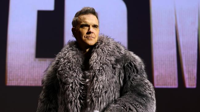 PARIS, FRANCE - DECEMBER 13: Robbie Williams speaks on stage during the "Better Man" special screening at  on December 13, 2024 in Paris, France. (Photo by Marc Piasecki/Getty Images for Paramount Pictures)