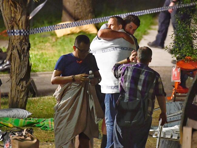 Walking wounded comfort each other after the balcony collapse. Picture: Jason Edwards