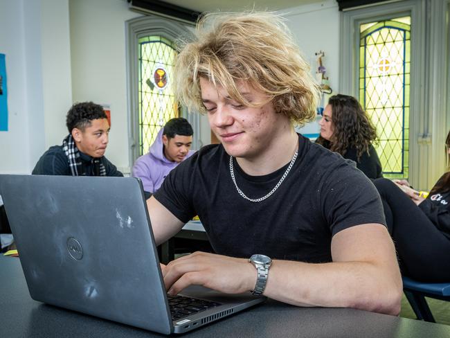 St Josephs in North Melbourne is an inclusive, supportive school for 12-25 year olds looking for an alternative to mainstream education. Students get free meals (breakfast, morning tea, lunch and afternoon tea), free mykis and there's no school fees or uniform. Marley (18) uses a laptop in a classroom. Picture: Jake Nowakowski