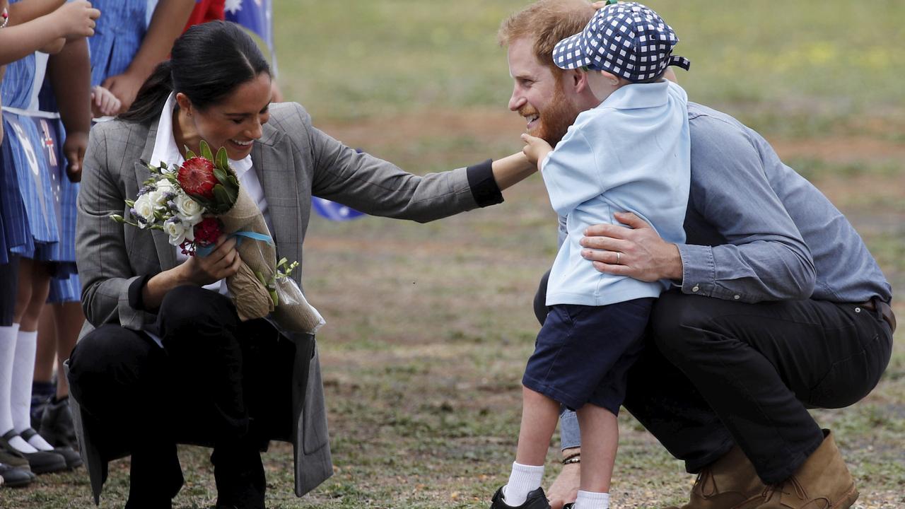 Expectant parents Meghan and Harry are embraced by Luke Vincent, 5, in Dubbo. Picture: Phil Noble