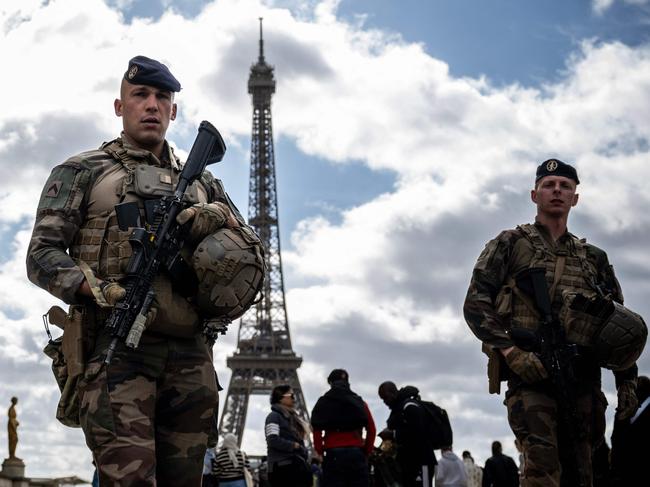 French soldiers from the Operation Sentinel patrol on the Trocadero Esplanade near the Eiffel Tower in Paris, on April 15, 2024. French President Emmanuel Macron has hinted in an interview at alternative solutions in the event of a major terrorist threat to the opening ceremony of the Paris 2024 Olympic Games. (Photo by JULIEN DE ROSA / AFP)