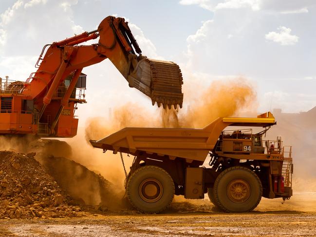 A haul truck is loaded by a digger with material from the pit at Rio Tinto Group's West Angelas iron ore mine in Pilbara, Australia, on Sunday, Feb. 19, 2012. Rio Tinto Group, the world's second-biggest iron ore exporter, will spend $518 million on the first driverless long-distance trains to haul the commodity from its Western Australia mines to ports, boosting efficiency. Photographer: Ian Waldie/Bloomberg via Getty Images