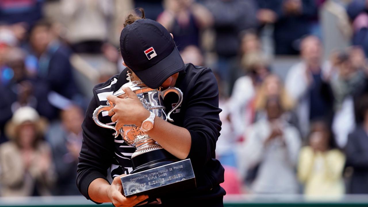 Australia's Ashleigh Barty hugs her trophy after winning the French Open. (Photo by Kenzo TRIBOUILLARD / AFP)
