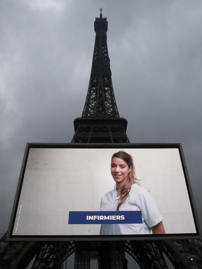 A large screen in front of Paris’ Eiffel Tower displays pictures to thank caregivers, volunteers and workers. Picture: AP