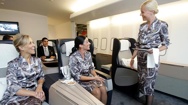 Qantas flight attendants serve French champagne in the first class section of mock 747.