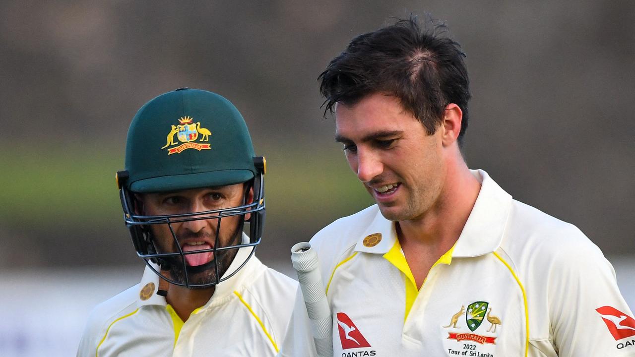 Australia's Nathan Lyon (R) and captain Pat Cummins walk back to the pavilion at the end of the second day play of the first cricket Test match between Sri Lanka and Australia at the Galle International Cricket Stadium in Galle on June 30, 2022. (Photo by ISHARA S. KODIKARA / AFP)