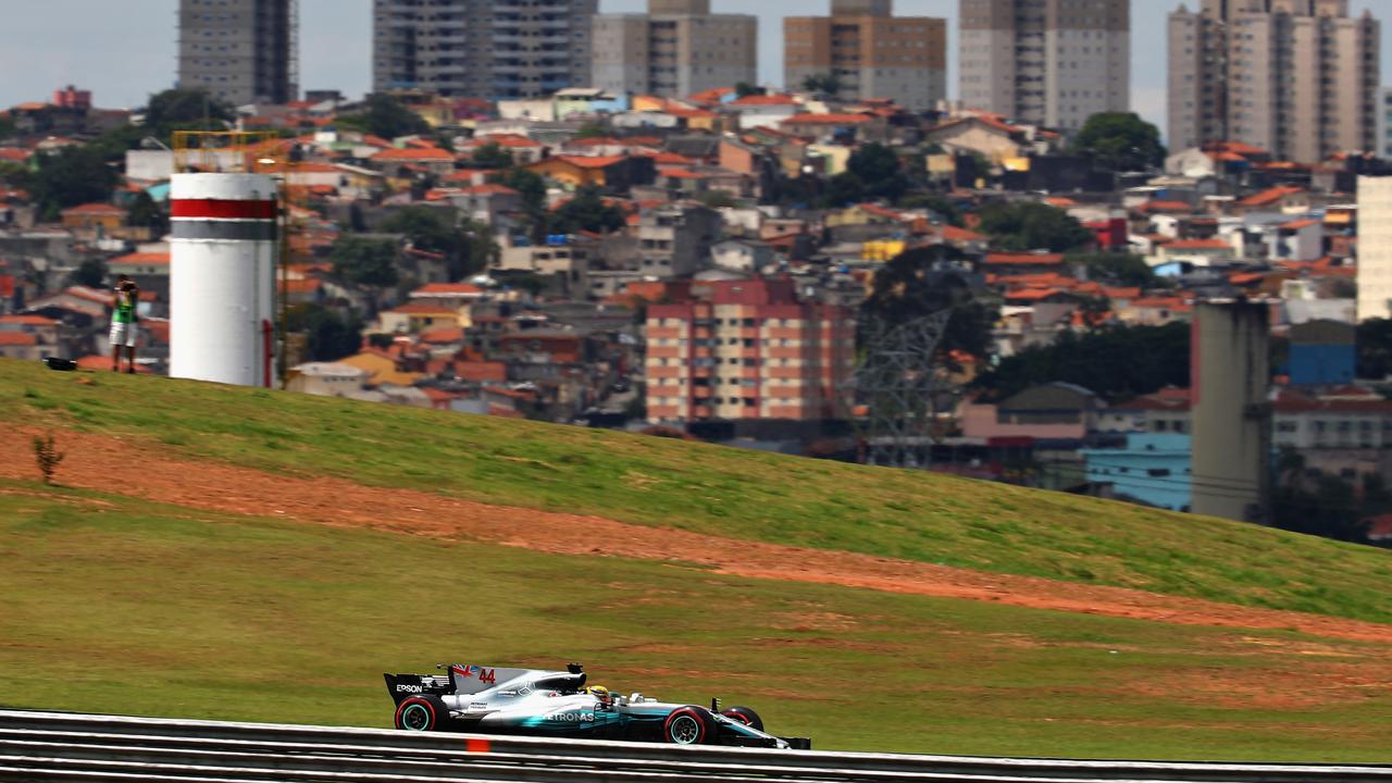 Lewis Hamilton drives in 2017 with the Sao Paulo skyline in the background.
