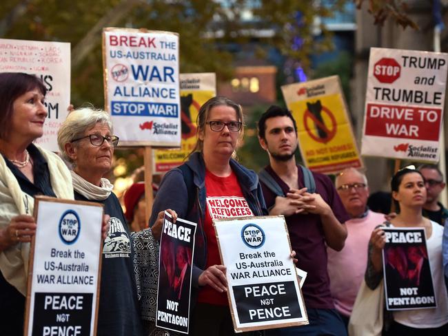 Protesters hold placards during a protest against the visit of US Vice President Mike Pence in Sydney.