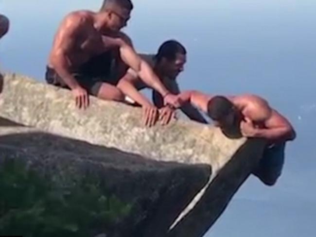 Daredevil pictured hanging off the side of a cliff. Picture: Caters News