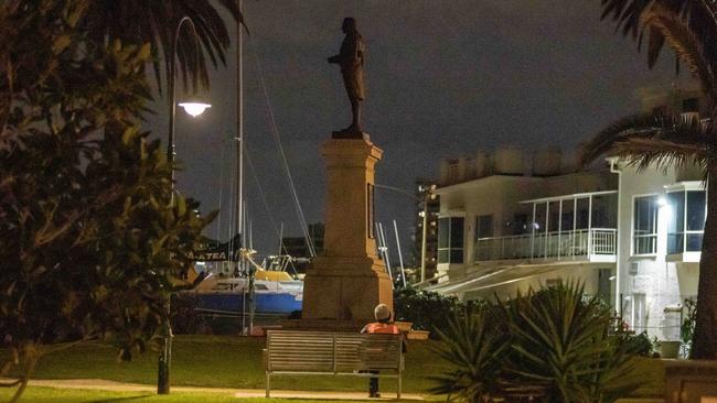 A security guard watches the. James Cook statue in St Kilda. Picture: Tim Carrafa