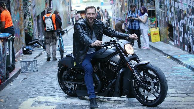 Travis Cloke on his Harley Davidson in Hosier Lane. Picture: Wayne Ludbey