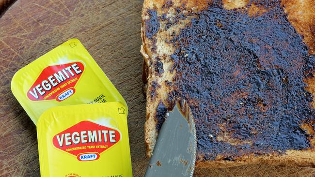 Reichenbach, Germany - 0ctober 4, 2013: Vegemite on Toast - Produce in Australia at Kraft Foods' Port Melbourne. It's a popular dark brown australian Food Paste - used as spread for sandwiches and toast - the Australian People love it for Breakfast. It taste similar to beef bouillon. I shot this photo at home in Germany - the Vegemite was a Souvenir from my Australia Trip. Toast with Knife and 2 small packages of Vegemite.