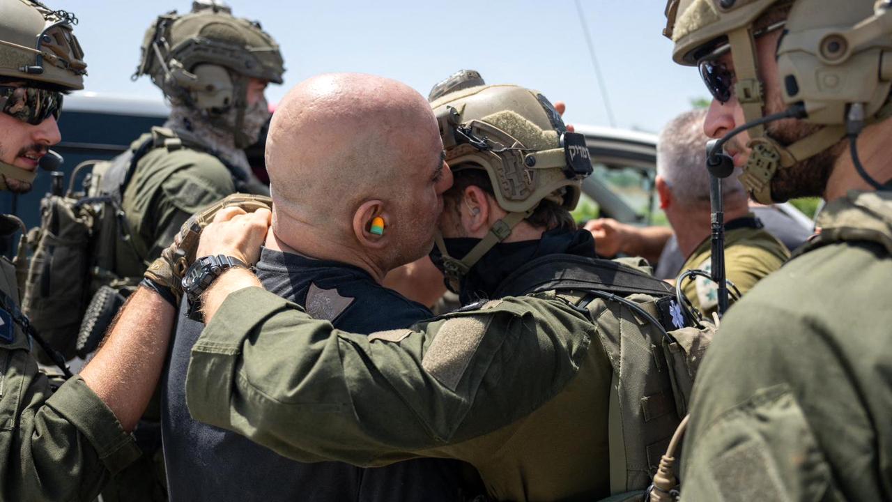 Former hostage Shlomi Ziv, 41, kissing a soldier in the grounds of the Sheba Tel-HaShomer Medical Centre. Picture: AFP