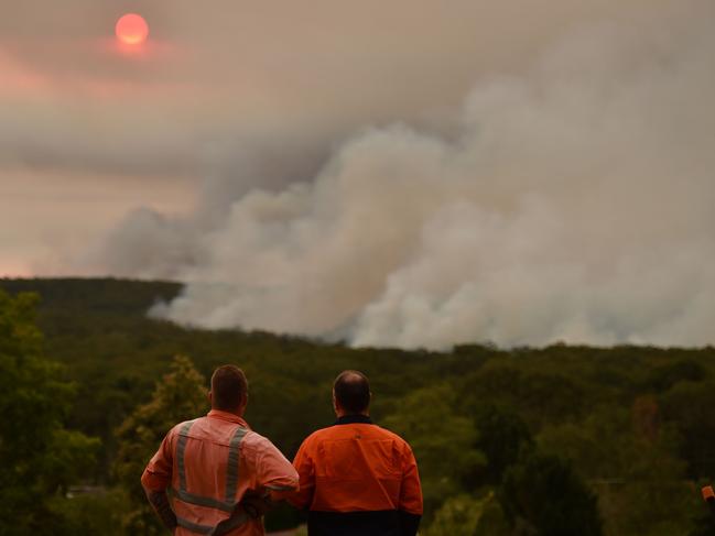 Residents watch a large bushfire as seen from Bargo, 150km southwest of Sydney. Unprecedented heatwaves have continued to fan out-of-control bushfires, destroying homes and smothering huge areas with toxic smoke. Picture: Peter Parks/AFP