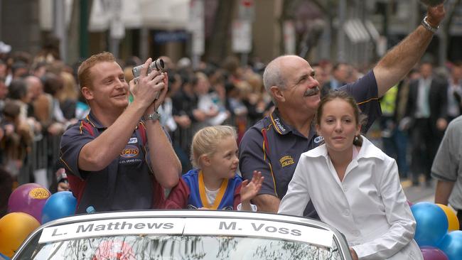 Captain Michael Voss and Coach Leigh Matthews wave to the crowd at the 2004 parade. Picture by Heath Missen.