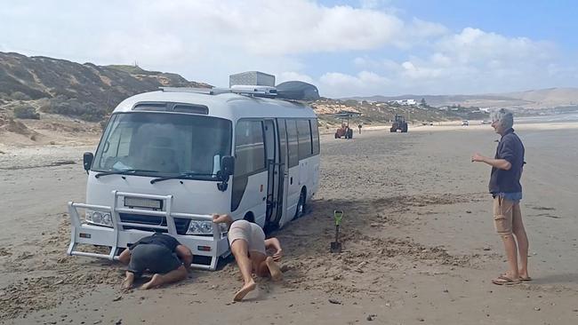 Beachgoers attempted to remove a bogged bus from Aldinga Beach on Thursday before the next high tide. Picture: Aden Hill