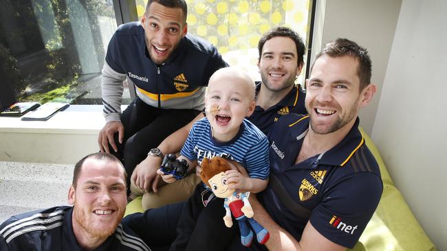 Hawthorn players Jarryd Roughead, Josh Gibson, Jordan Lewis and Luke Hodge with Daniel Burn, 3, during a visit to the Royal Children's Hospital for the On The Boot charity. Picture: David Caird