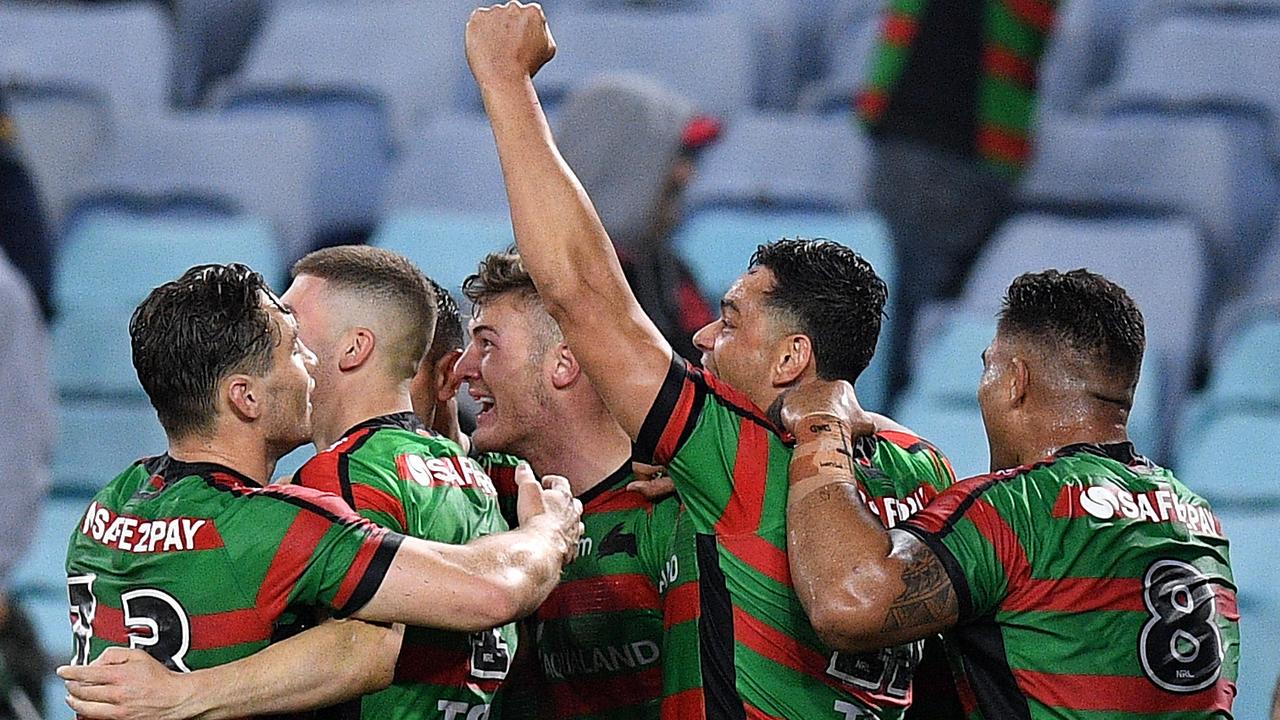 Campbell Graham of the Rabbitohs (centre) celebrates with teammates after scoring the match winning try in the dying seconds against the Dragons.