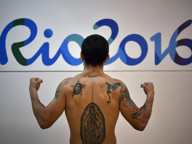 TOPSHOT - Argentina's Ignacio Perrin shows off his tattoos after a boxing training session at the Riocentro complex in Rio de Janeiro on August 4, 2016, ahead of the Rio 2016 Olympic Games. / AFP PHOTO / YURI CORTEZ