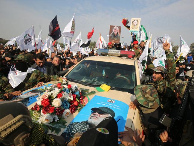 Mourners surround a car carrying the coffin of Iraqi paramilitary chief Abu Mahdi al-Muhandis (image) during a funeral procession. Picture: AFP