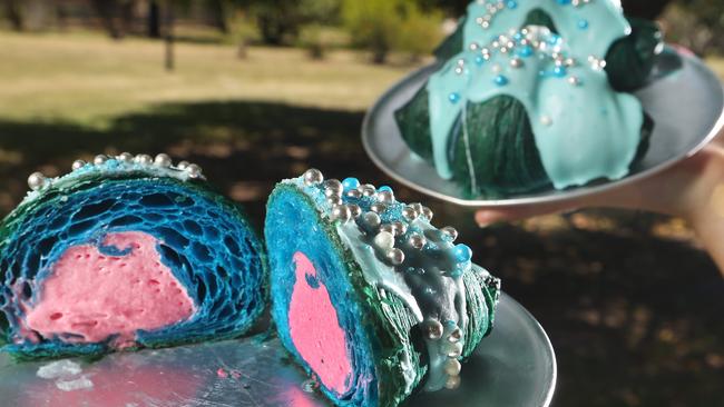 Staff member Susannah Hunt holds a Mermaid Croissant with fairy floss flavoured filling at Bam Bam Bakehouse. Picture Glenn Hampson