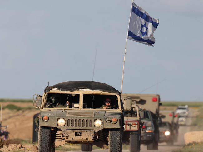 TOPSHOT - This picture taken from a position in southern Israel near the border with the Gaza Strip shows armoured personnel carriers leaving Gaza, on March 4, 2024, amid continuing battles between Israel and the Palestinian militant group Hamas. (Photo by Menahem KAHANA / AFP)