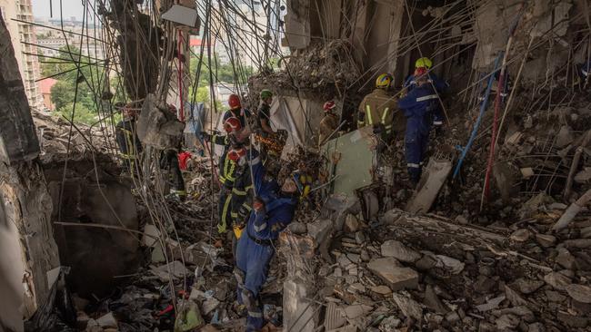 Emergency personnel clear rubble in search for victims in the heavily damaged apartment building that was hit by a downed Russian missile. Picture: Getty