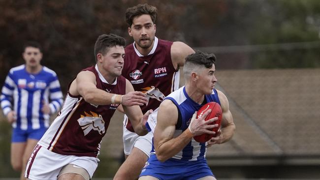 EFL: Ferntree Gully’s Alex Bull tries to escape two defenders. Picture: Valeriu Campan