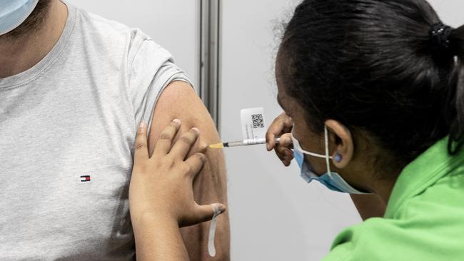 BRISBANE AUSTRALIA - NewsWire Photos NOVEMBER 1, 2021: Rhys Barnes gets a Pfizer vaccination from enrolled nurse Maria Mathews at the Brisbane Convention and Exhibition centre vaccination hub. NewsWire / Sarah Marshall