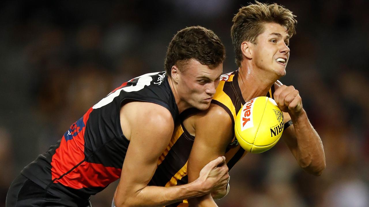 MELBOURNE, AUSTRALIA - MARCH 20: Daniel Howe of the Hawks is tackled by Nikolas Cox of the Bombers during the 2021 AFL Round 01 match between the Essendon Bombers and the Hawthorn Hawks at Marvel Stadium on March 20, 2021 in Melbourne, Australia. (Photo by Michael Willson/AFL Photos via Getty Images)