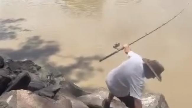 The fisherman loses his footing while trying to reel in his catch. Picture: Jody Chisholm