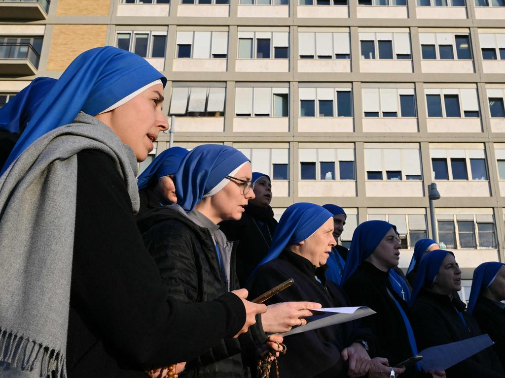 Nuns sing at the statue of John Paul II outside the Gemelli hospital where Pope Francis is hospitalised in Rome on February 22, 2025. Picture: Alberto PIZZOLI / AFP