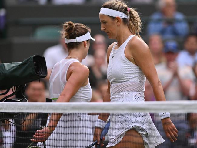 Belarus' Victoria Azarenka (R) passes by Ukraine's Elina Svitolina during their women's singles tennis match on the seventh day of the 2023 Wimbledon Championships at The All England Tennis Club in Wimbledon, southwest London, on July 9, 2023. (Photo by Glyn KIRK / AFP) / RESTRICTED TO EDITORIAL USE