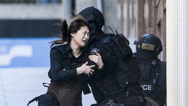 Jieun Bae is taken into the arms of a member of the NSW Police tactical Operations Unit after she fled the Lindt cafe in Martin Place, Sydney. She was among 18 hostages of the cafe held by Man Haron Monis. Picture: Chris McKeen