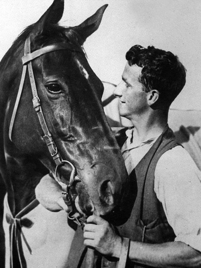 Strapper Tommy Woodcock with racehorse Phar Lap in New Zealand, en route to Mexico in 1932.