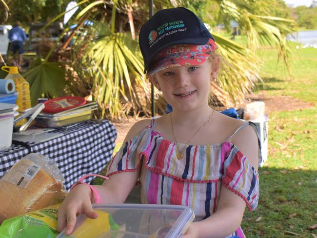 Samara Zirbel didn’t participate in the Tilapia Takedown, instead she had fun helping out in the Blue River Mackay Lions Club stall. Picture: Lillian Watkins