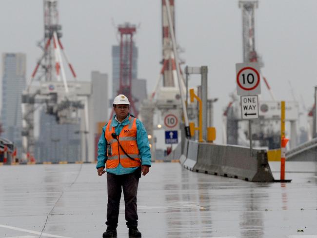 Security guards keep watch at the entrance to the West Gate Tunnel project site at Yarraville before this morning's employee lay-offs. Picture: Andrew Henshaw