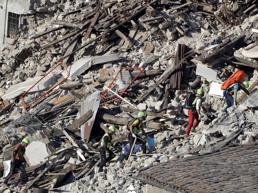 Rescuers make their way through destroyed houses following an earthquake in Pescara Del Tronto, central Italy, Thursday, Aug. 25, 2016. The magnitude 6 quake struck Wednesday at 3:36 a.m. (0136 GMT) and was felt across a broad swath of central Italy, including Rome where residents of the capital felt a long swaying followed by aftershocks. (AP Photo/Gregorio Borgia)