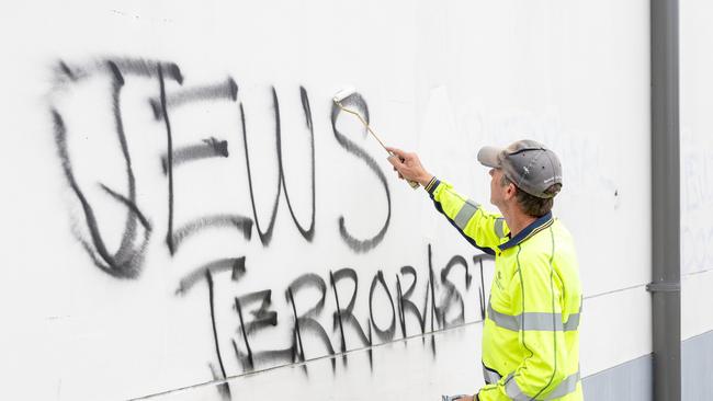 Graffiti removalists paint over the anti-Semitic graffiti on Mount Sinai College in Maroubra. Picture: Thomas Lisson