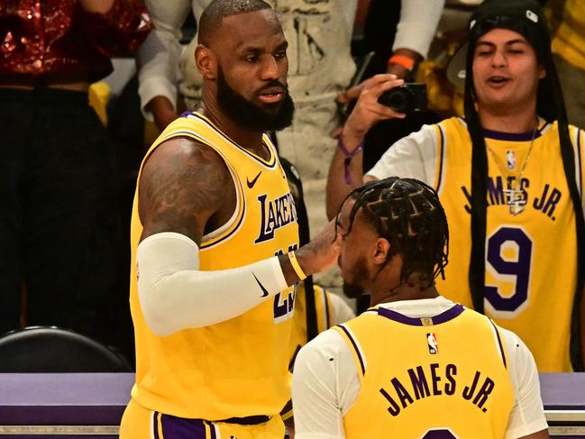 Los Angeles Lakers' US small forward #23 LeBron James (L) and Los Angeles Lakers' US guard #09 Bronny James are seen on court during the NBA game season opener between the Los Angeles Lakers and the Minnesota Timberwolves at Crypto Arena in Los Angeles on October 22, 2024. LeBron and Bronny are the first father and son to play together in any NBA game. (Photo by Frederic J. Brown / AFP)