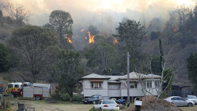 Fire and Emergency crew battle bushfire near a house in the rural town of Canungra in the Scenic Rim region of South East Queensland, Friday, September 6, 2019. (AAP Image/Regi Varghese)